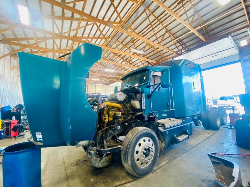 Semi in a T&E service bay with the hood up
